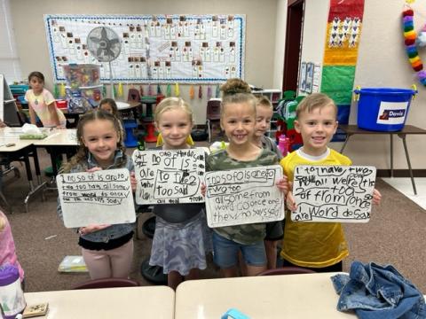 Students pose with the words they wrote on their whiteboards. 
