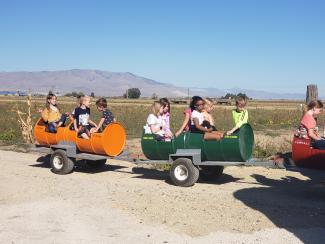 Students riding behind a tractor. 